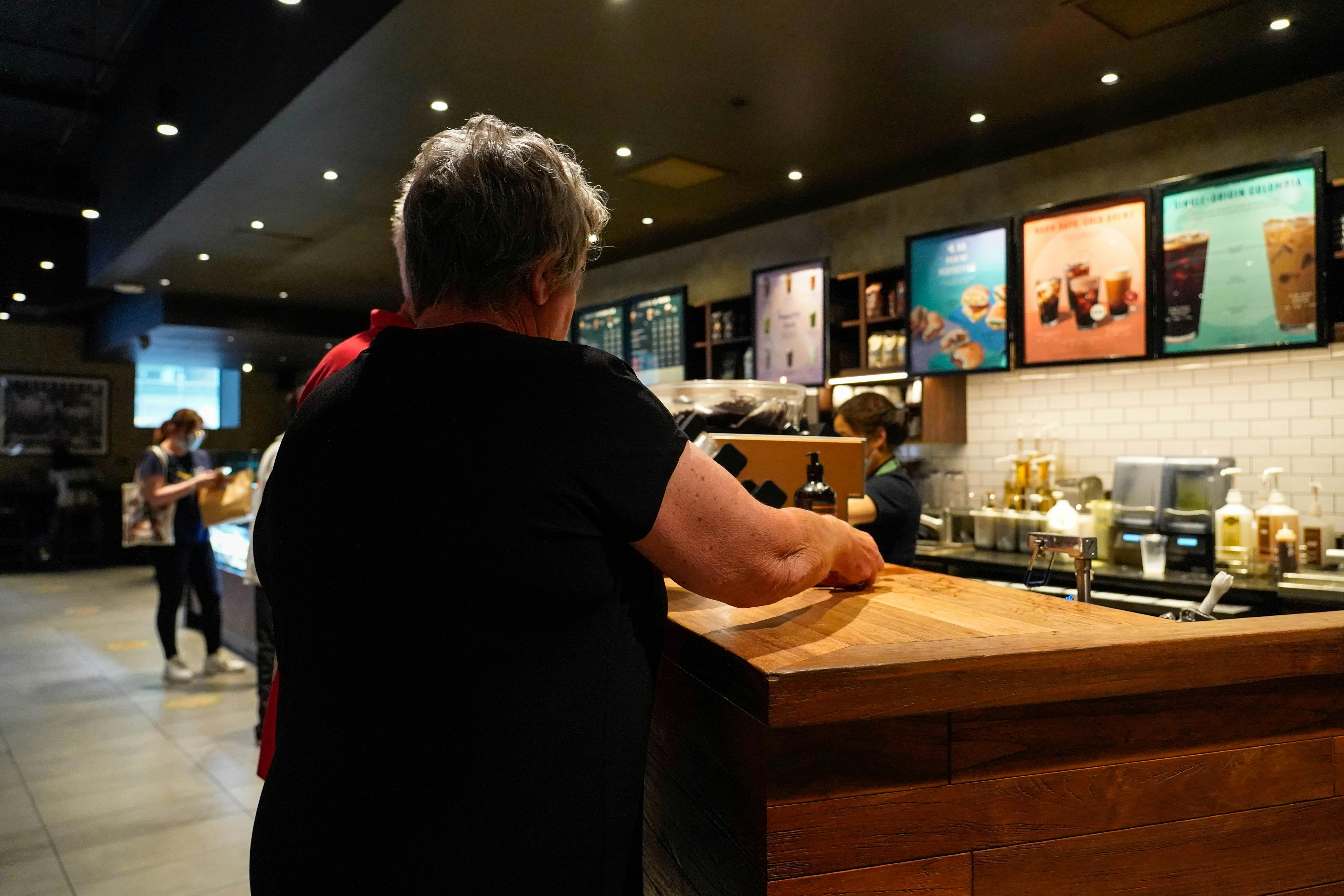 a person standing at a counter in a restaurant