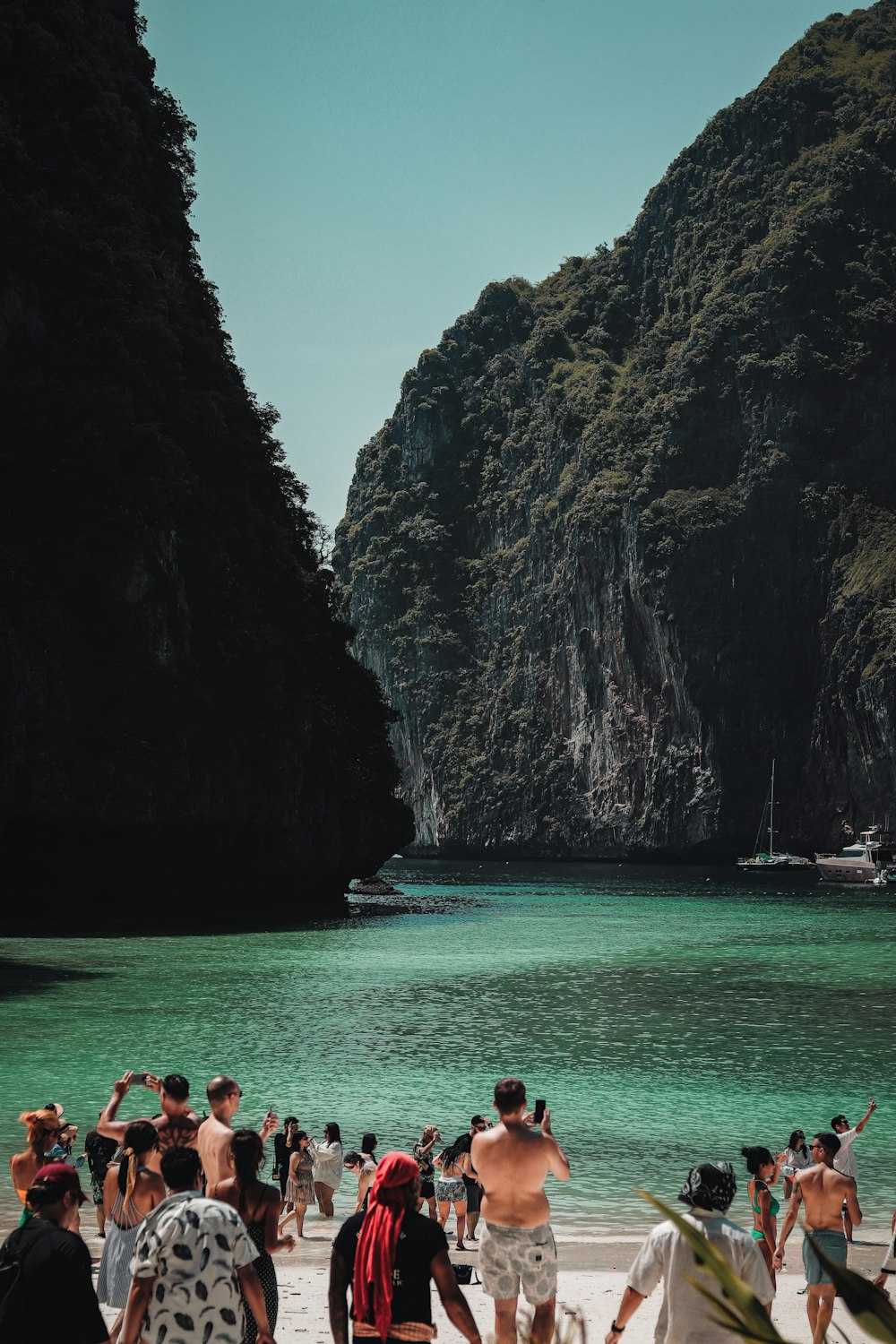 a group of people standing on top of a sandy beach