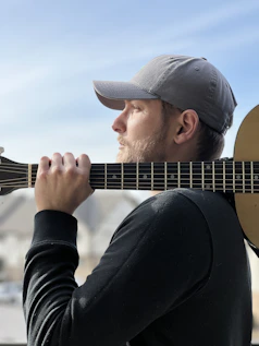 a man holding a guitar up to his face