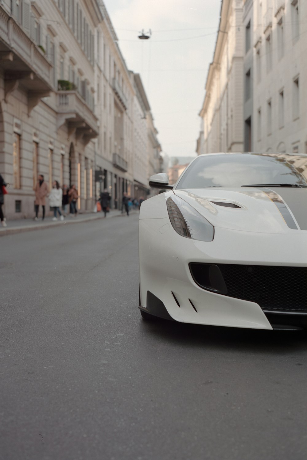 a white sports car parked on the side of a street