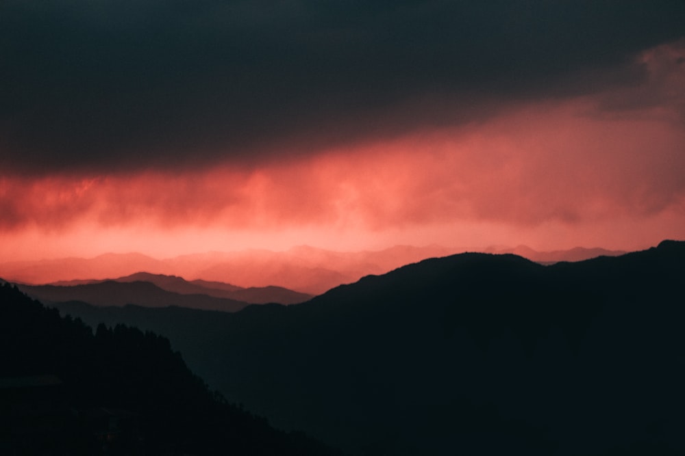 a red and black sky over a mountain range