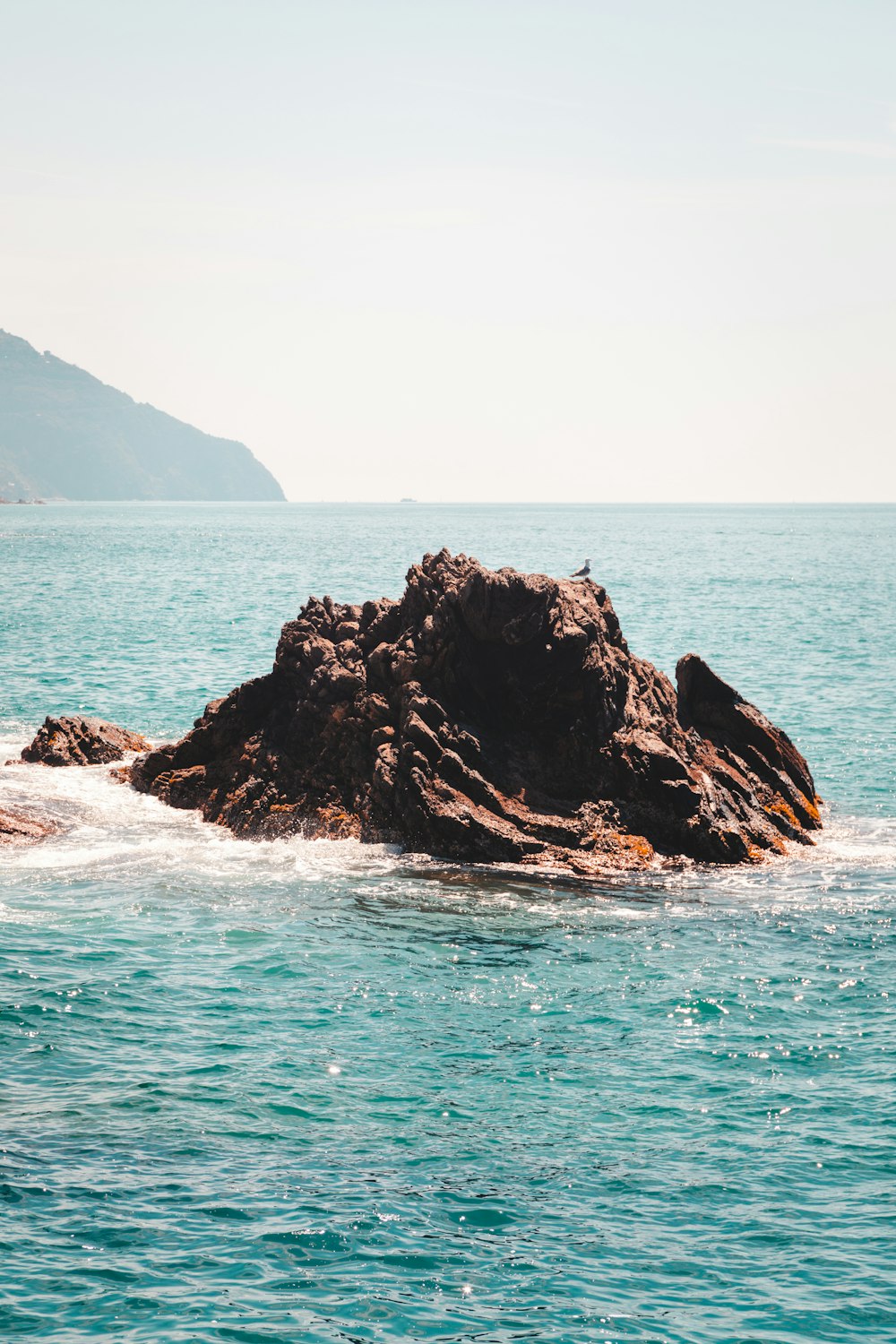 a large rock in the middle of the ocean