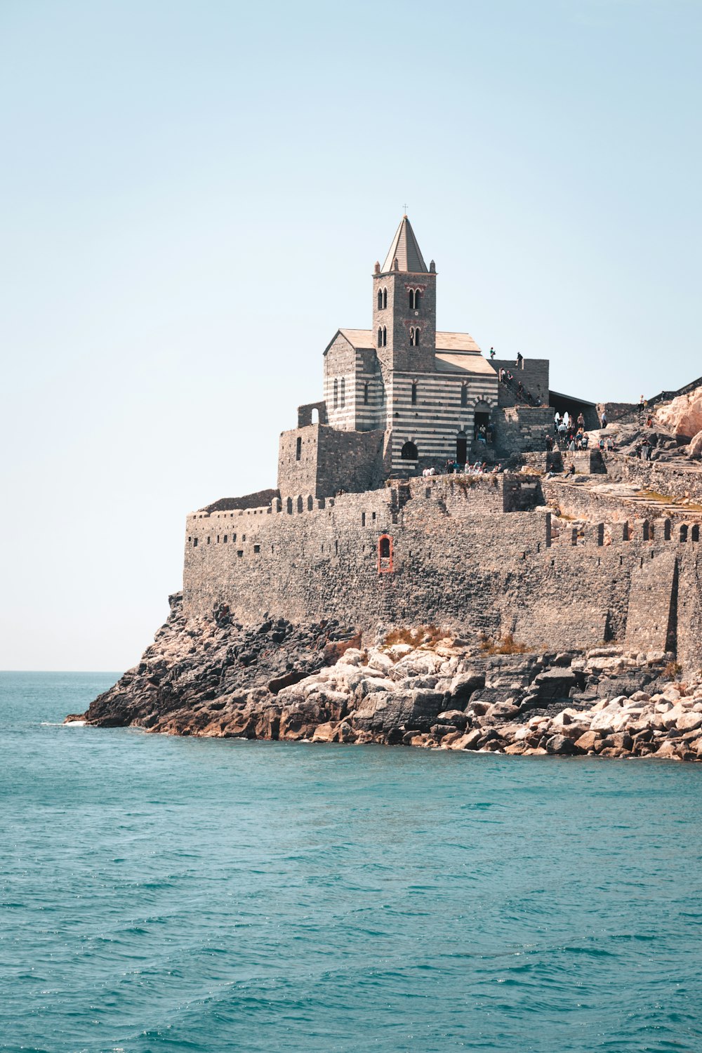 a castle on a rock outcropping in the middle of the ocean