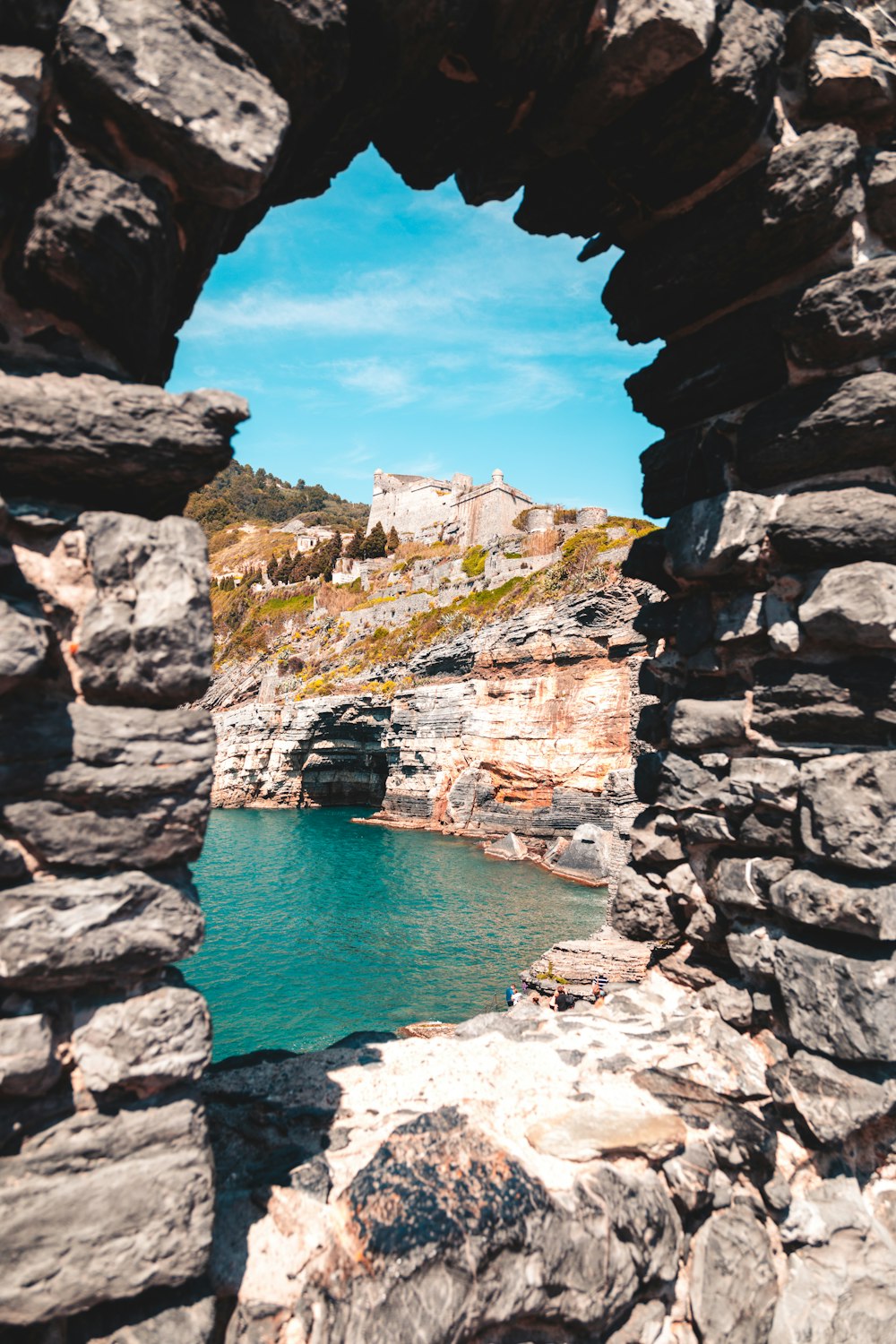 a view of a body of water through a stone wall