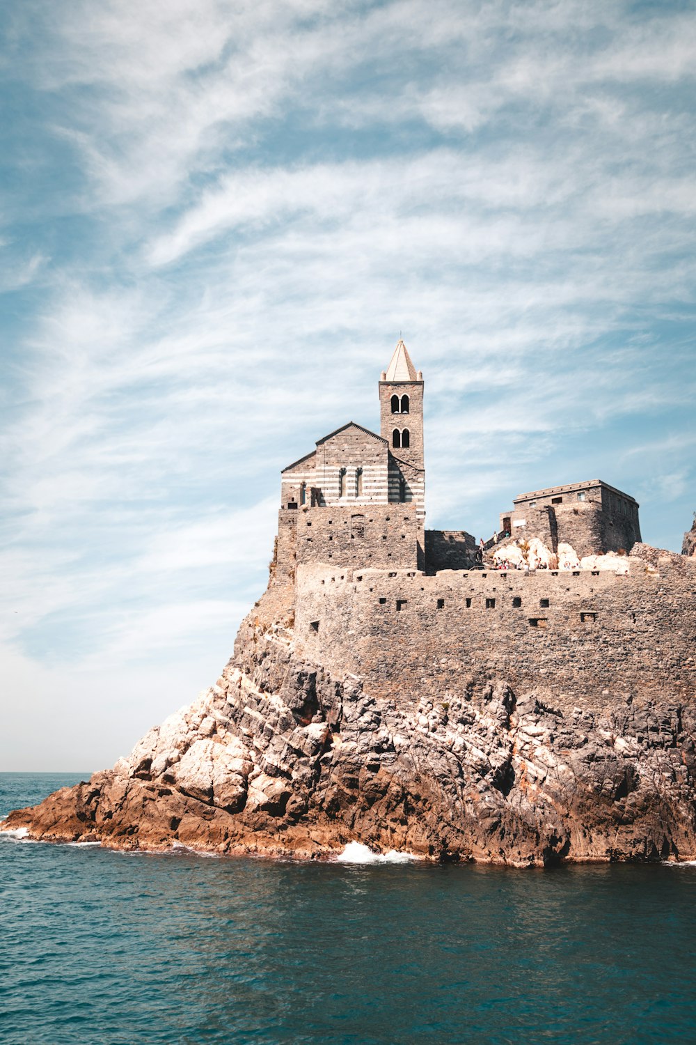 a large building sitting on top of a rocky island