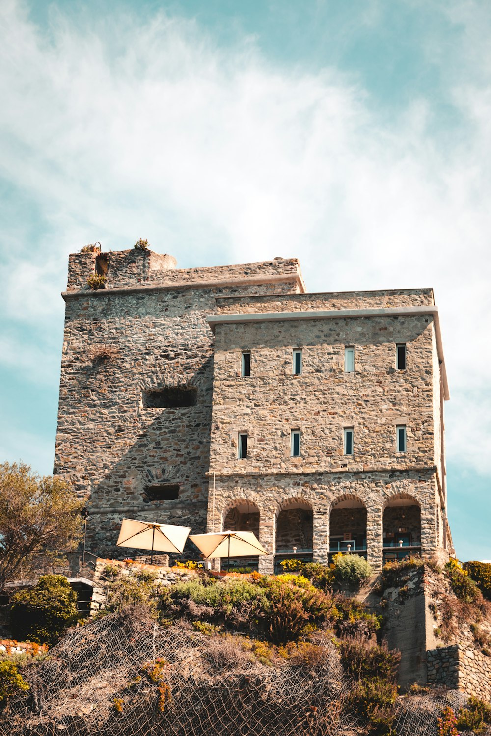 un grand bâtiment en pierre au sommet d’une colline