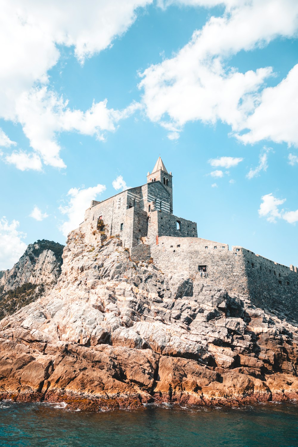 a castle on top of a rock outcropping in the ocean