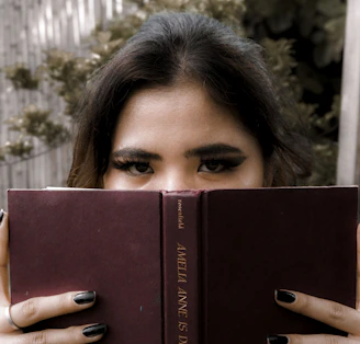 a woman holding a book in front of her face