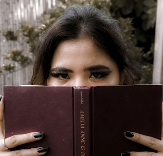 a woman holding a book in front of her face