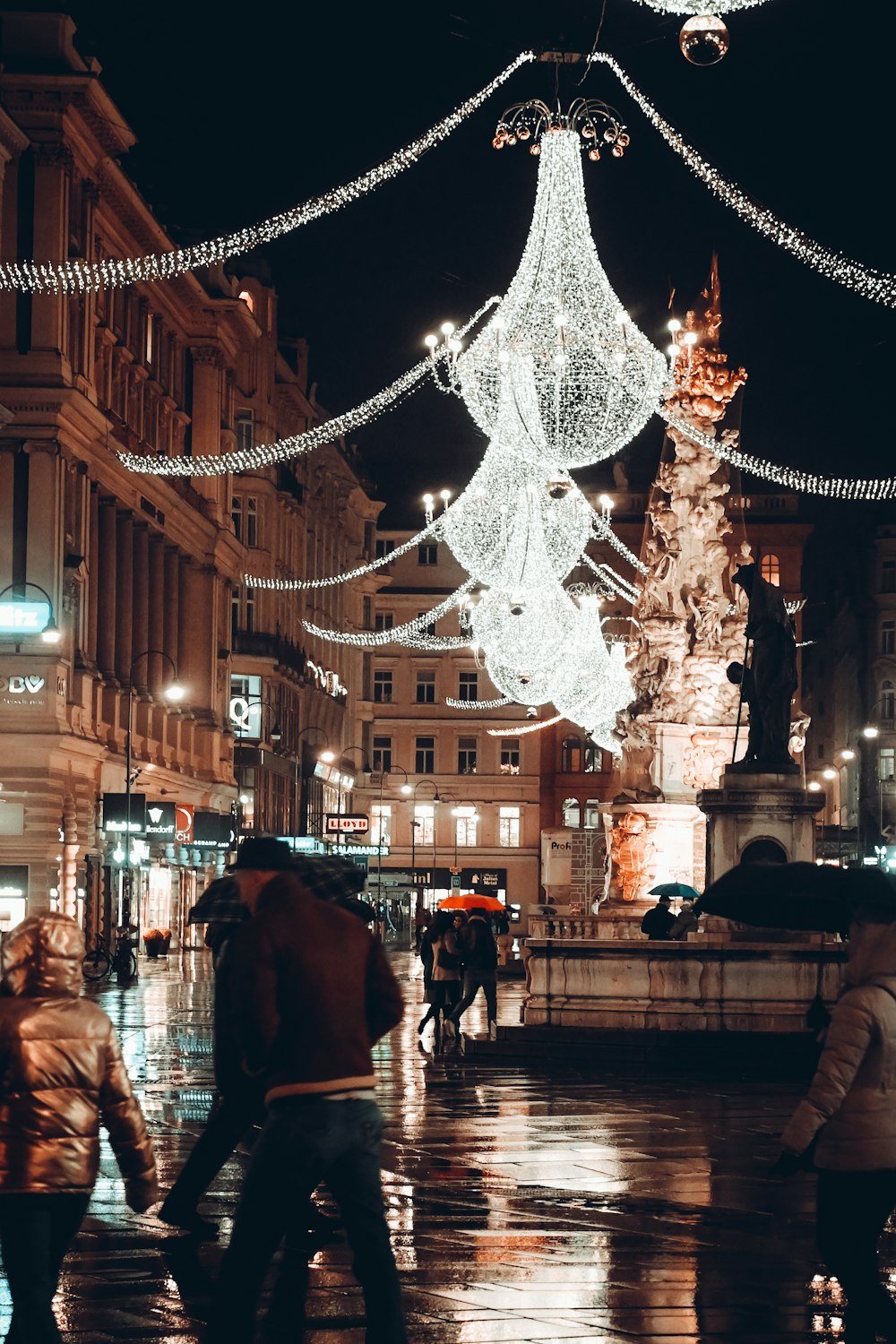 a group of people walking down a street at night