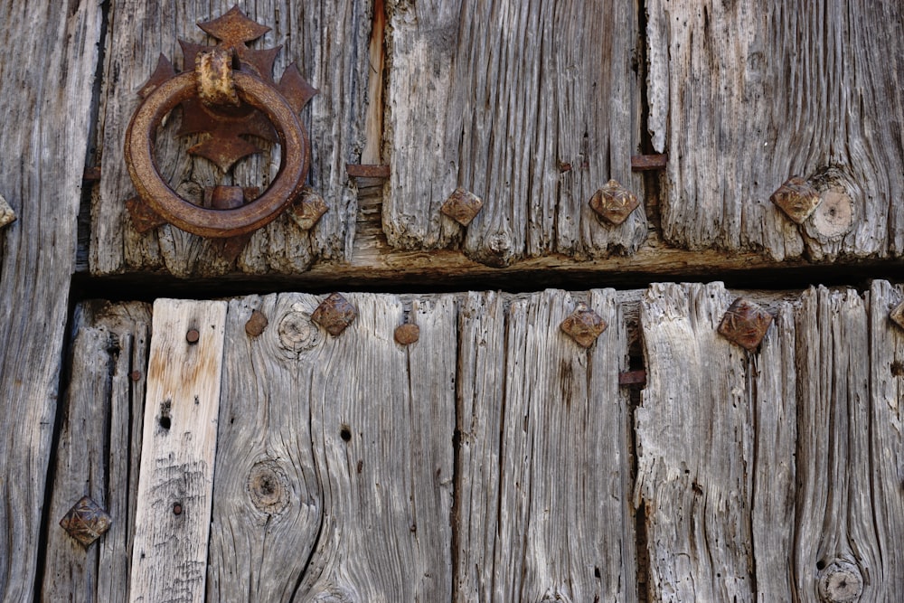 a close up of a wooden door with a metal ring