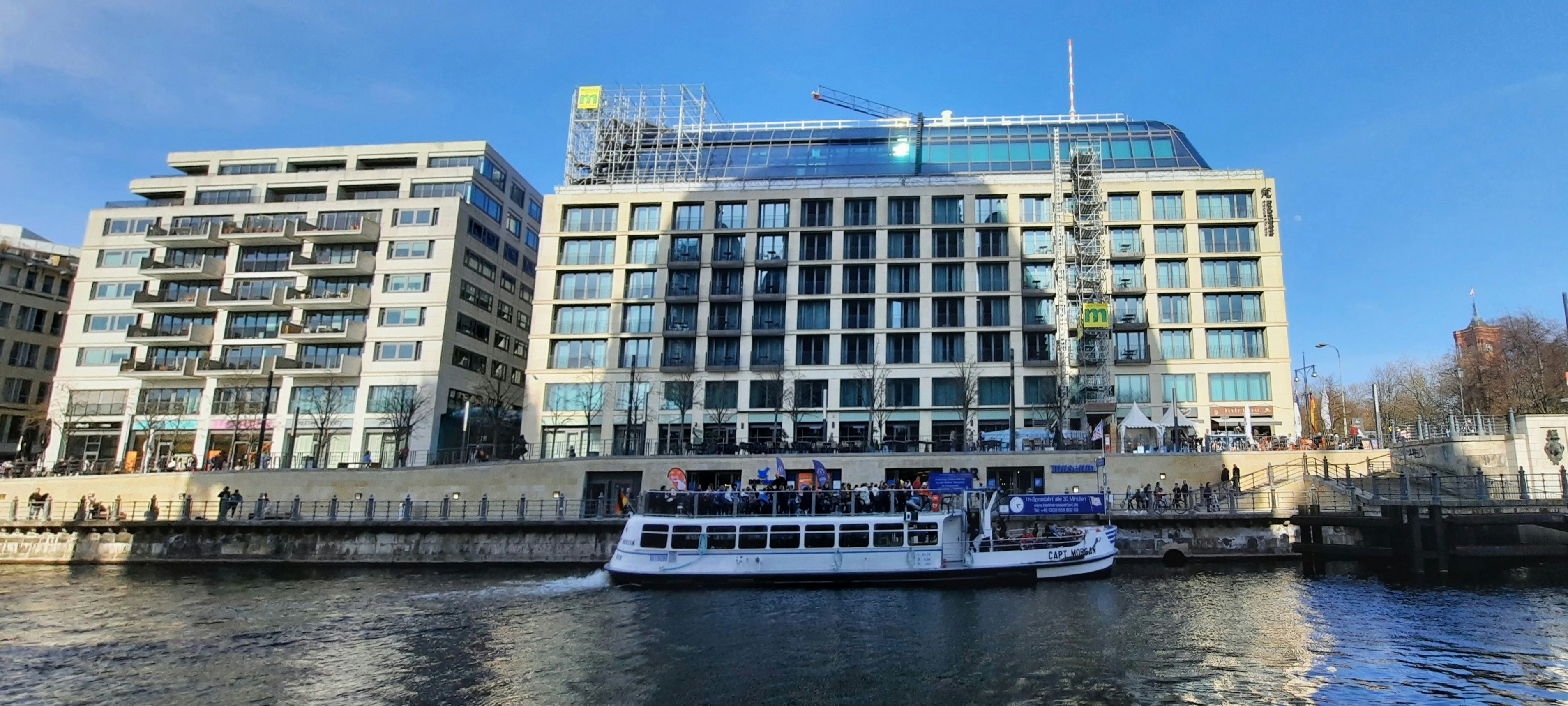 a large boat in a body of water near a large building