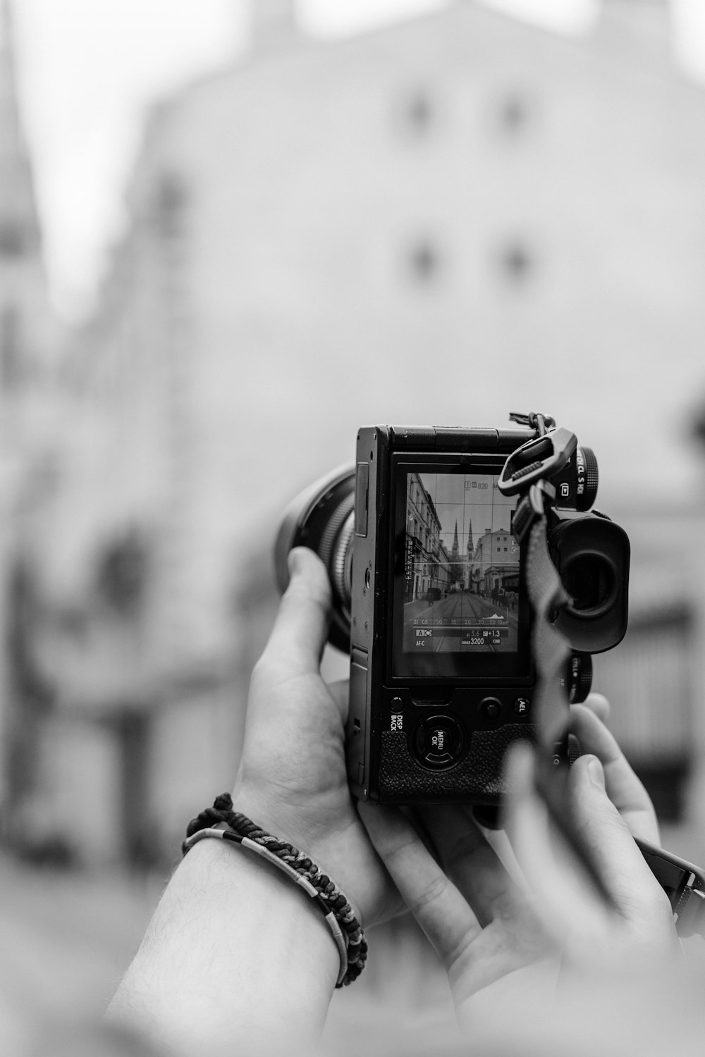 a black and white photo of a person holding a camera