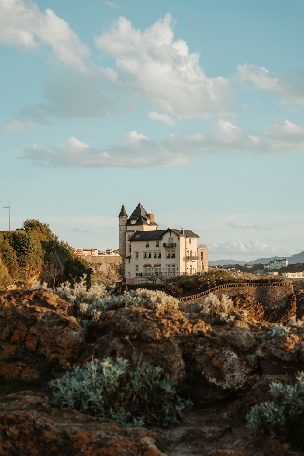 Un grande edificio bianco seduto sulla cima di una collina rocciosa