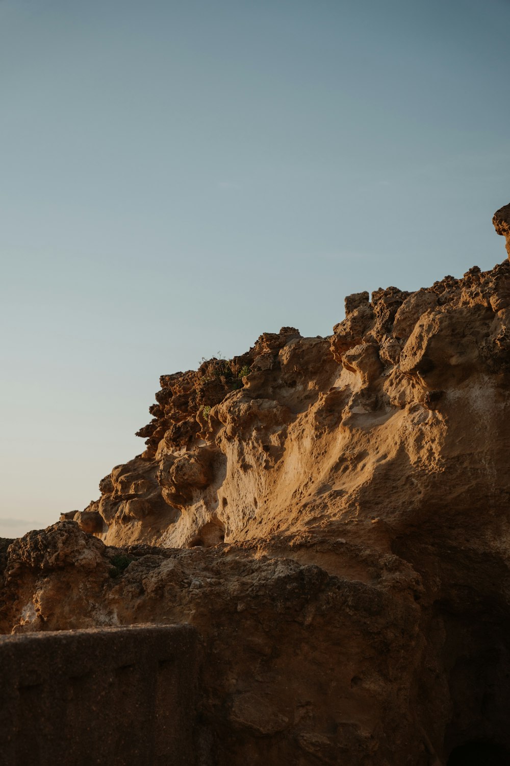 a man riding a surfboard on top of a rocky cliff