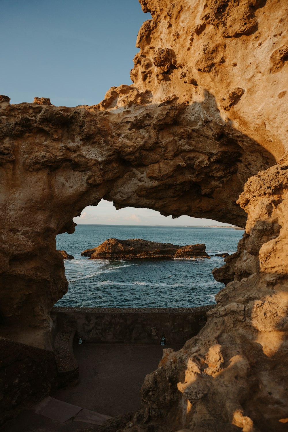 a view of the ocean through a rock arch