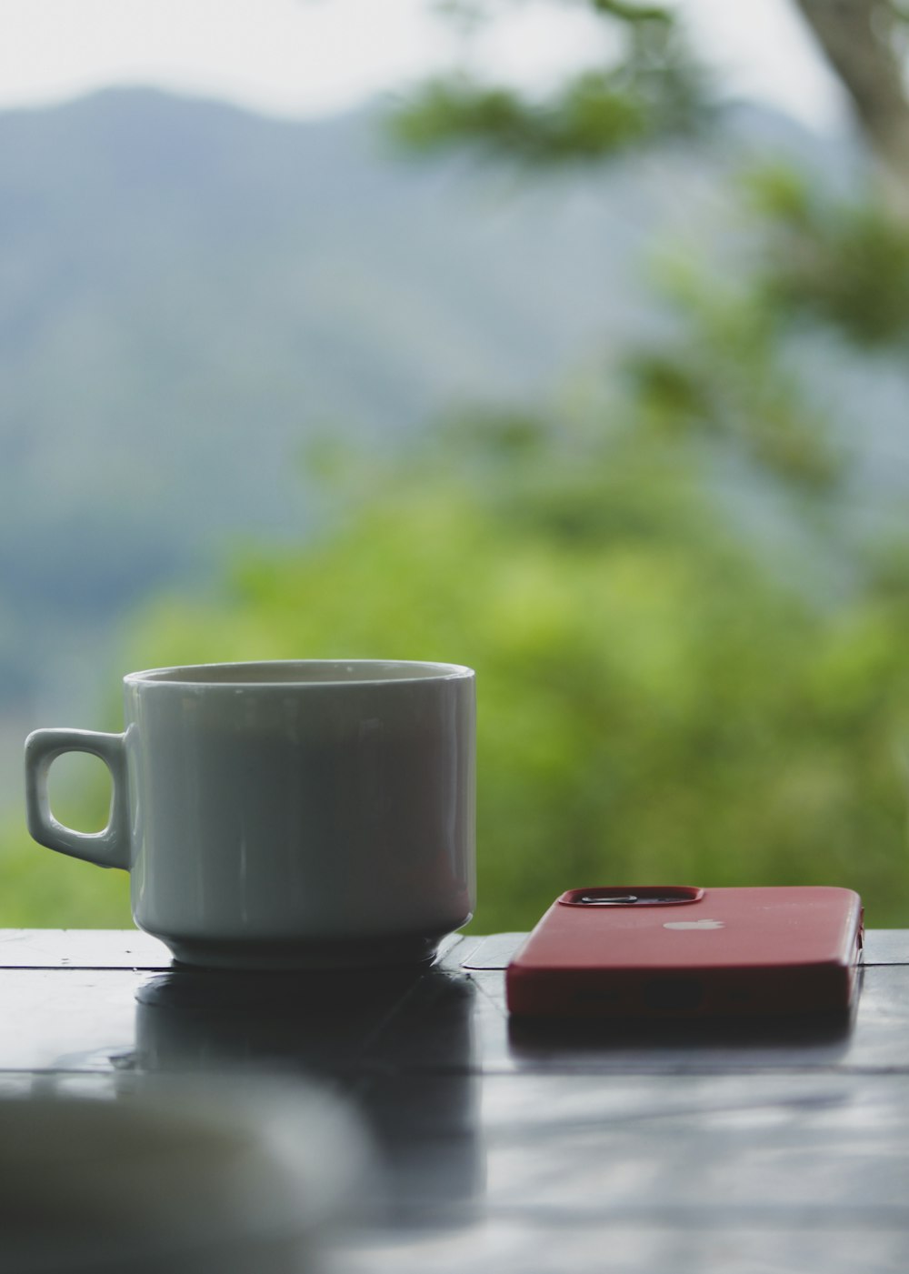a cup of coffee and a cell phone on a table
