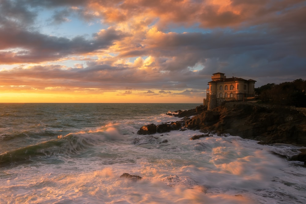 a house sitting on top of a cliff next to the ocean