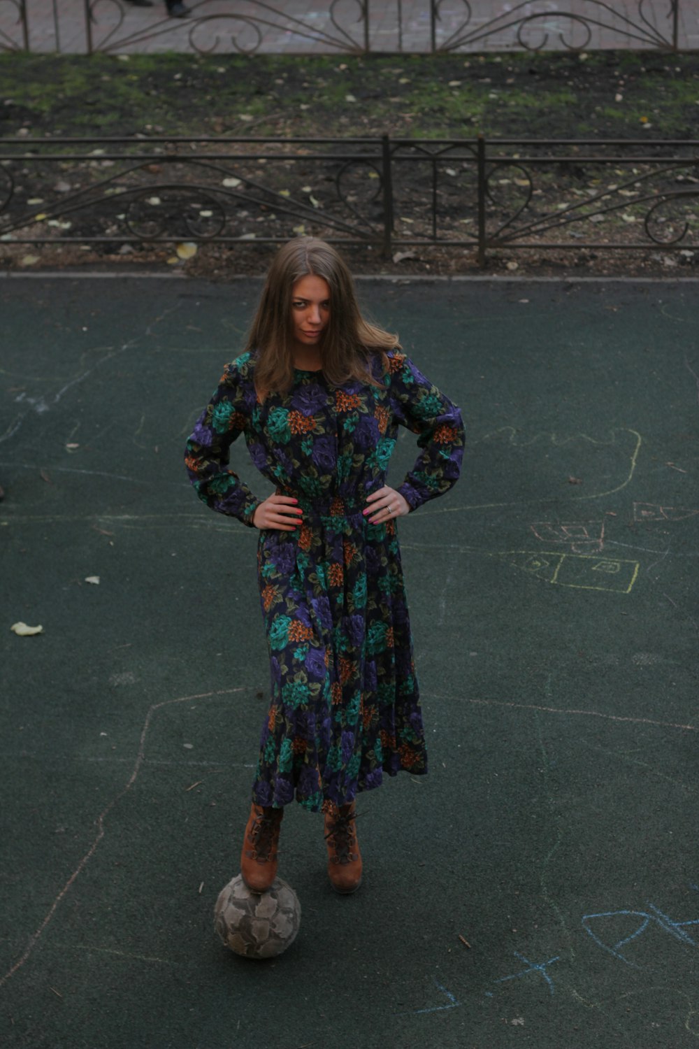 a woman standing on a soccer ball in a park