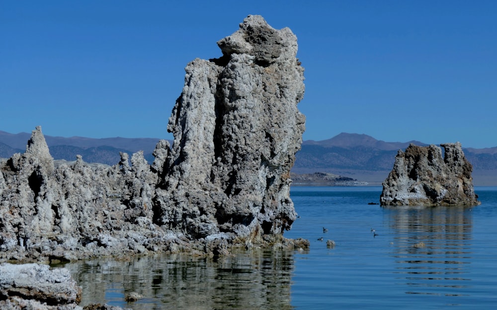 a large rock formation in the middle of a body of water