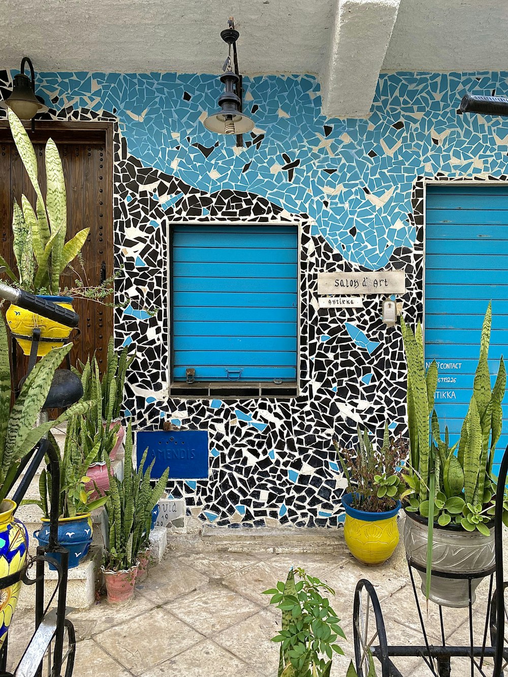 a building with blue shutters and a bike parked in front of it