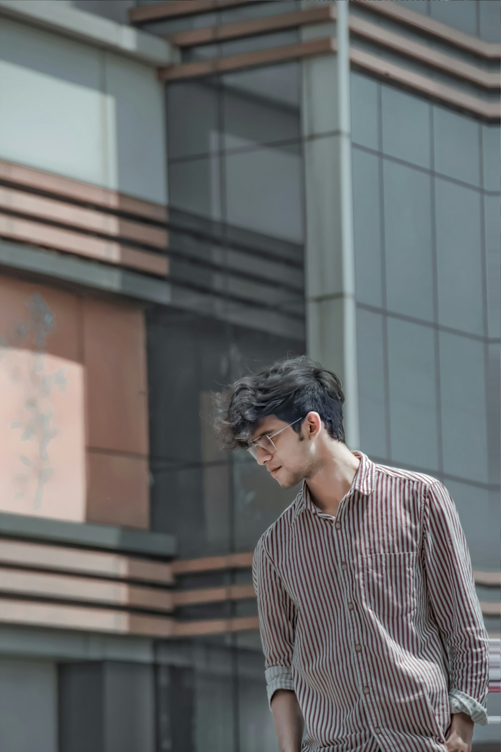 a young man standing in front of a tall building