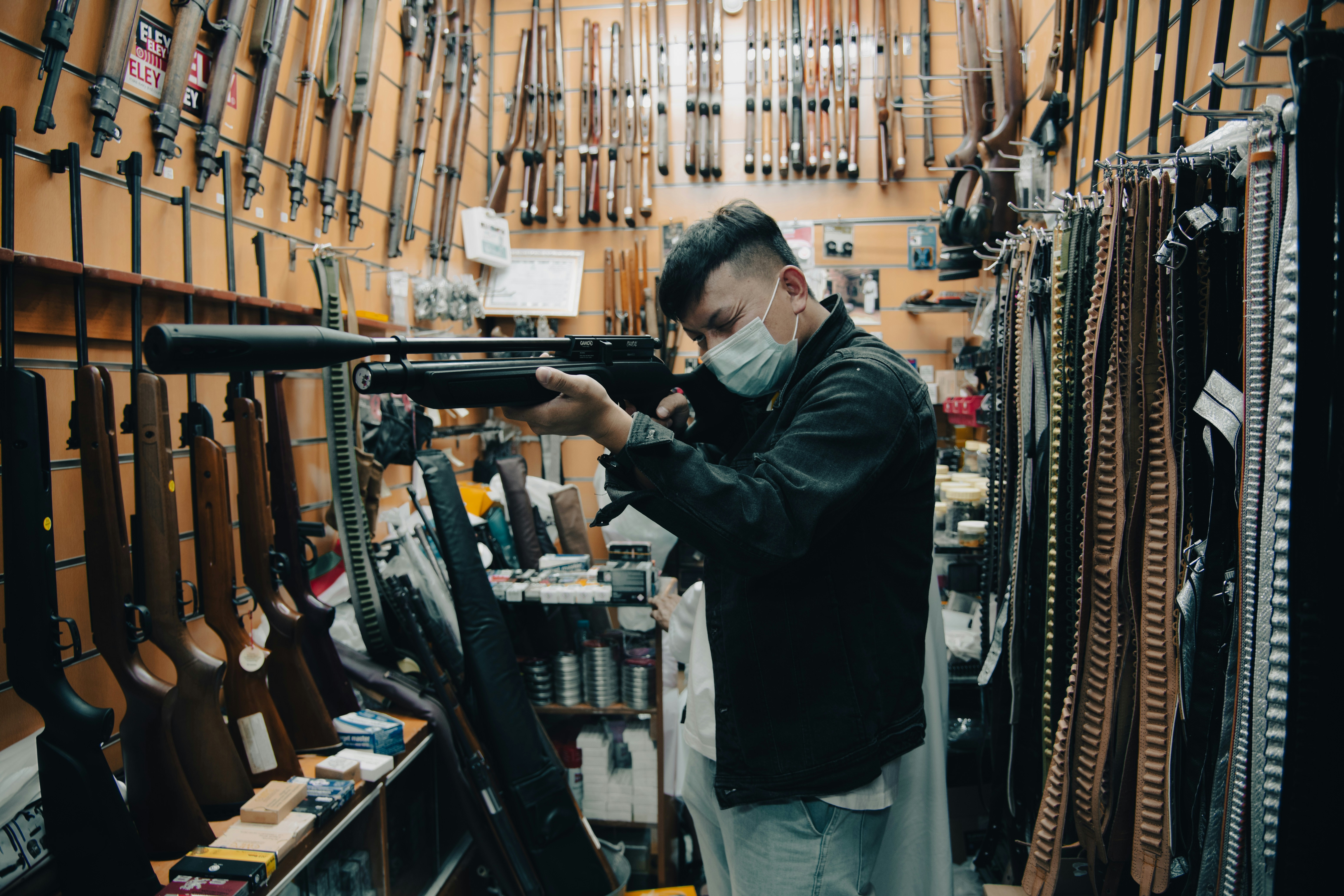a man wearing a face mask holding a rifle