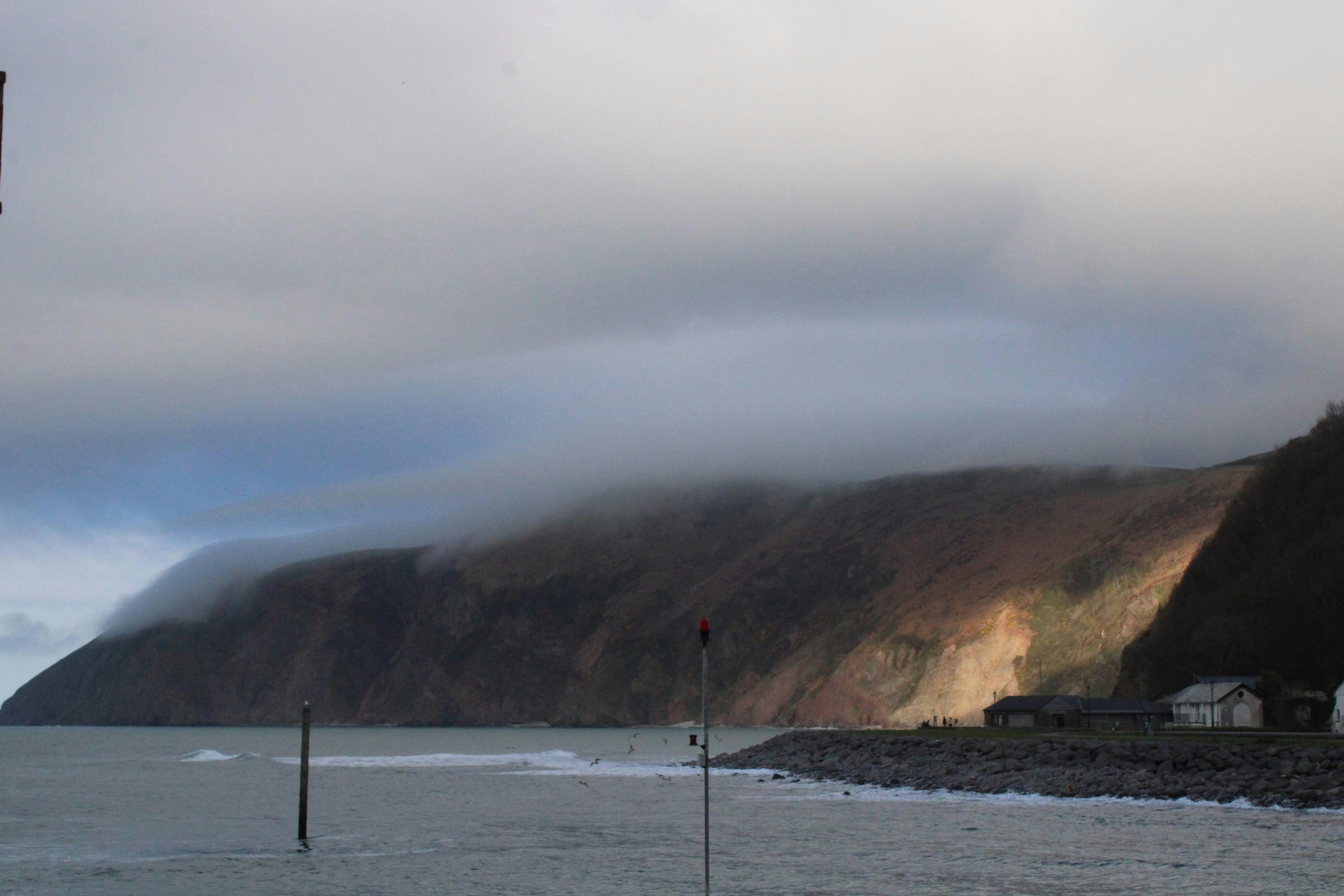 a large body of water with a mountain in the background