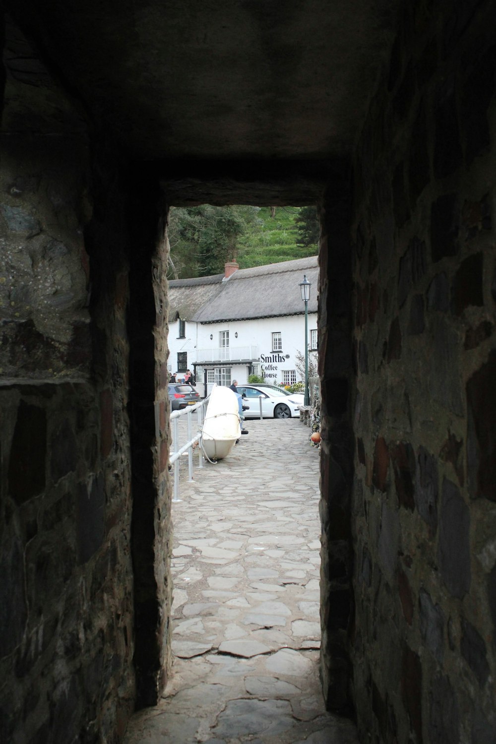 a view of a building through a stone tunnel