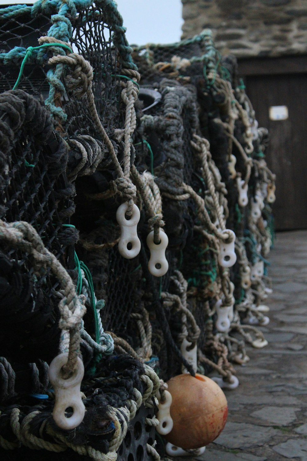 a row of fishing nets sitting on top of a stone floor