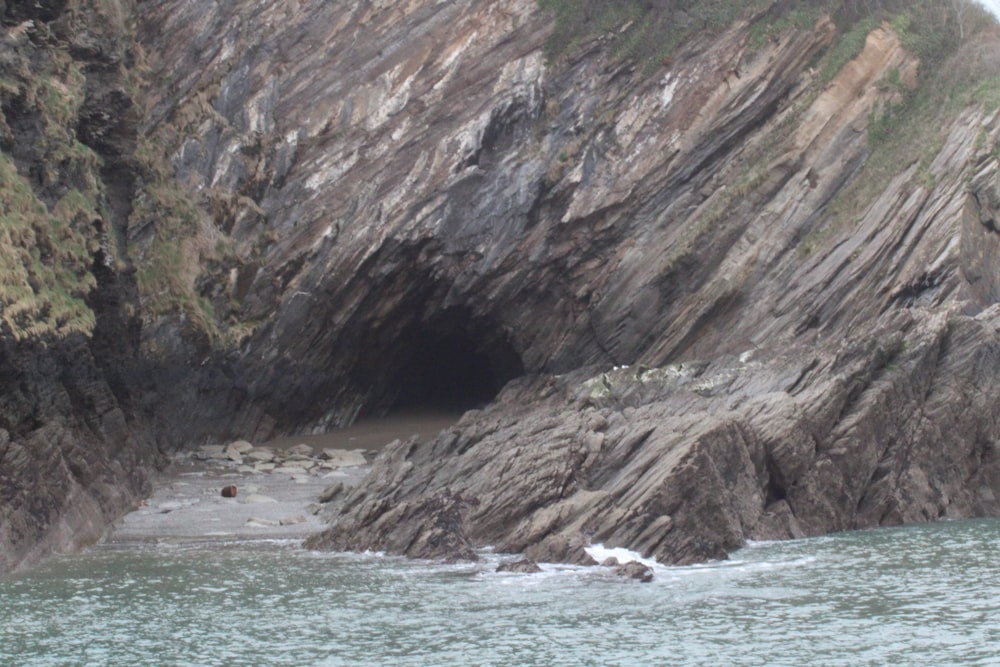 a large rock formation next to a body of water