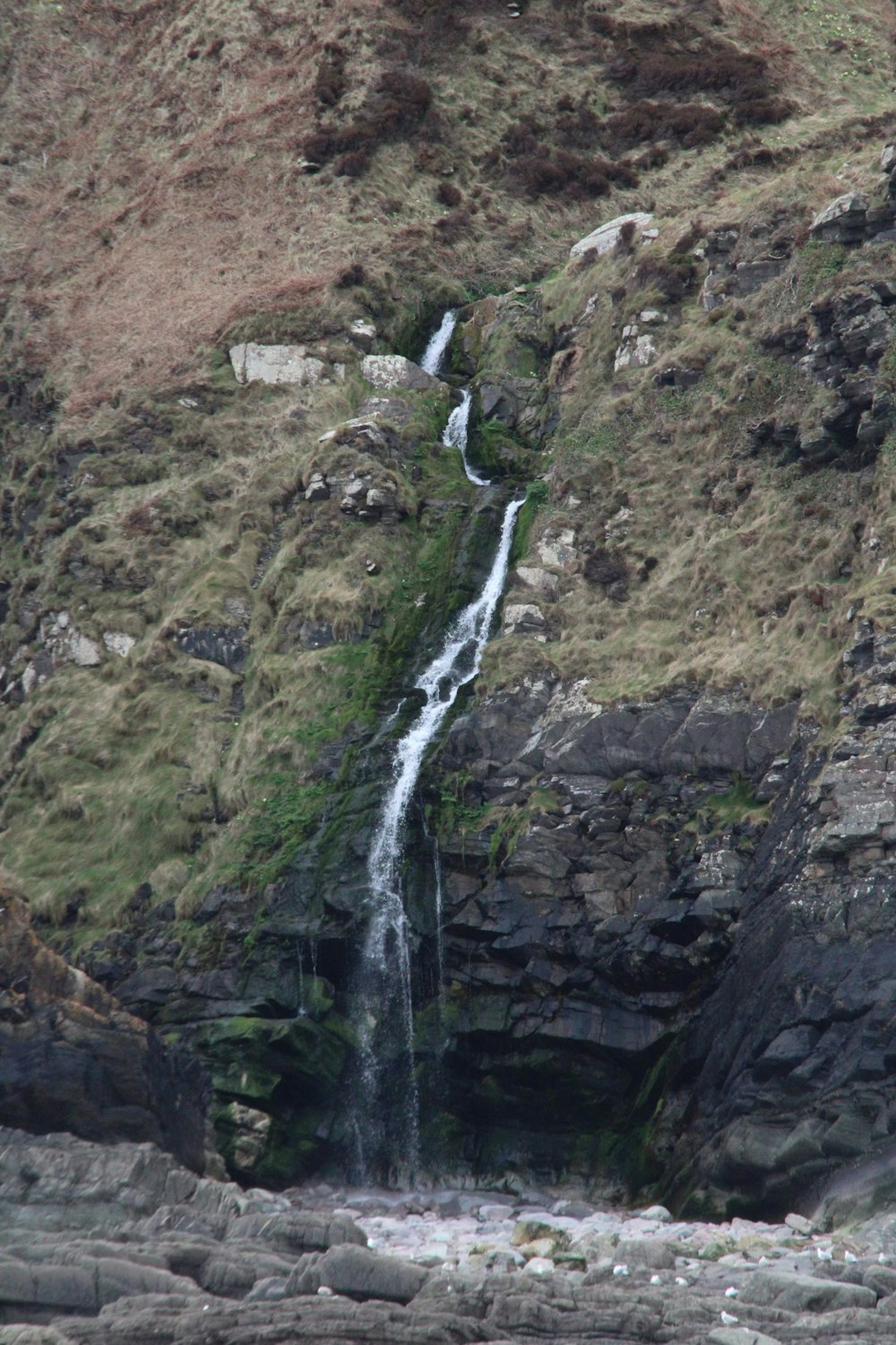 a waterfall is coming down the side of a mountain