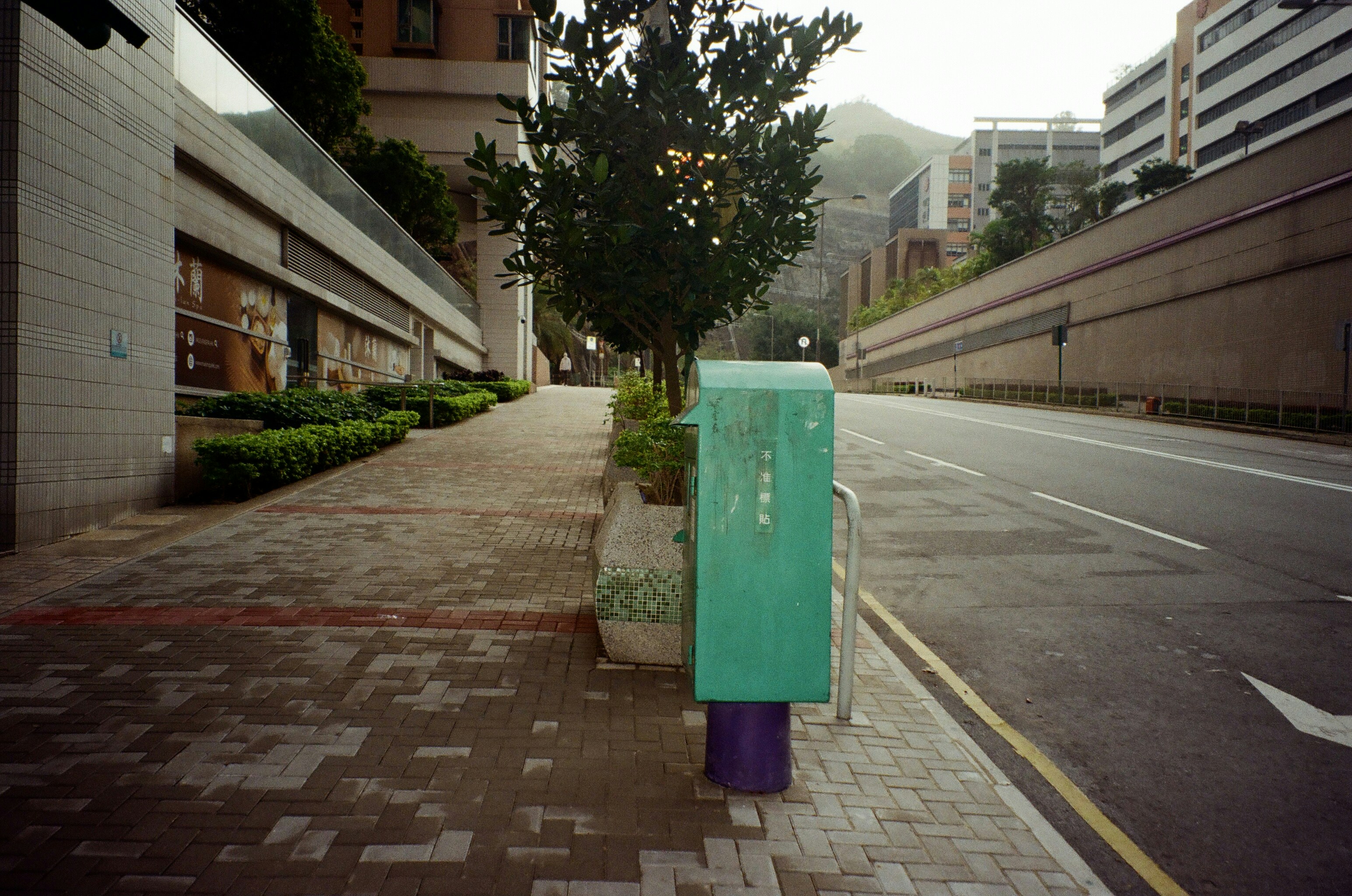 a green box sitting on the side of a road