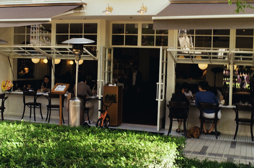 a group of people sitting at a table outside of a restaurant