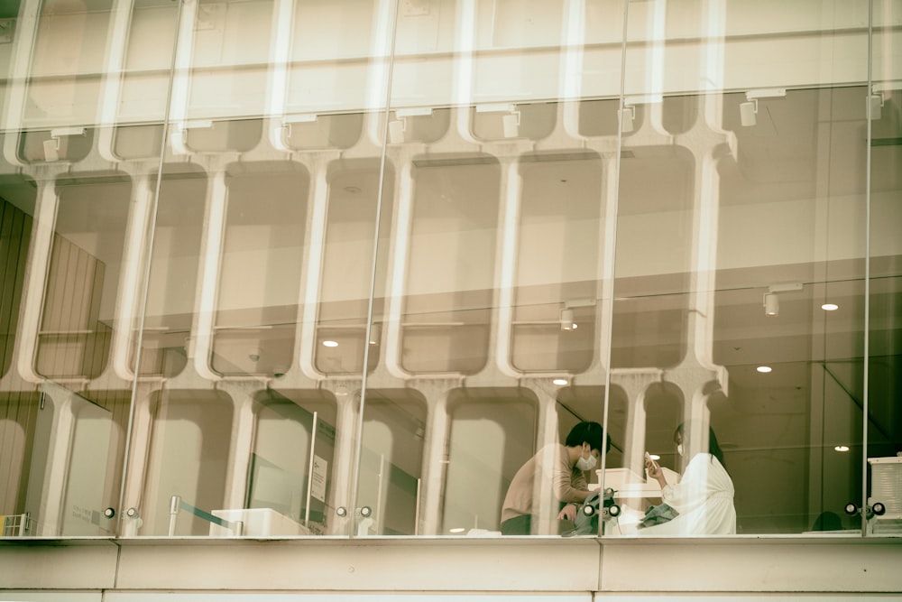 a couple of people sitting at a table in front of a window