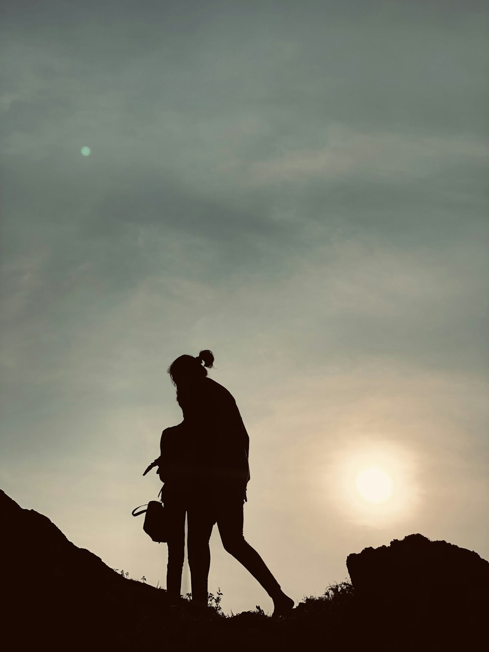 a person standing on top of a hill with a backpack