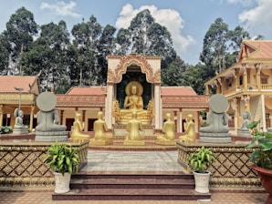 a golden buddha statue sitting in front of a building