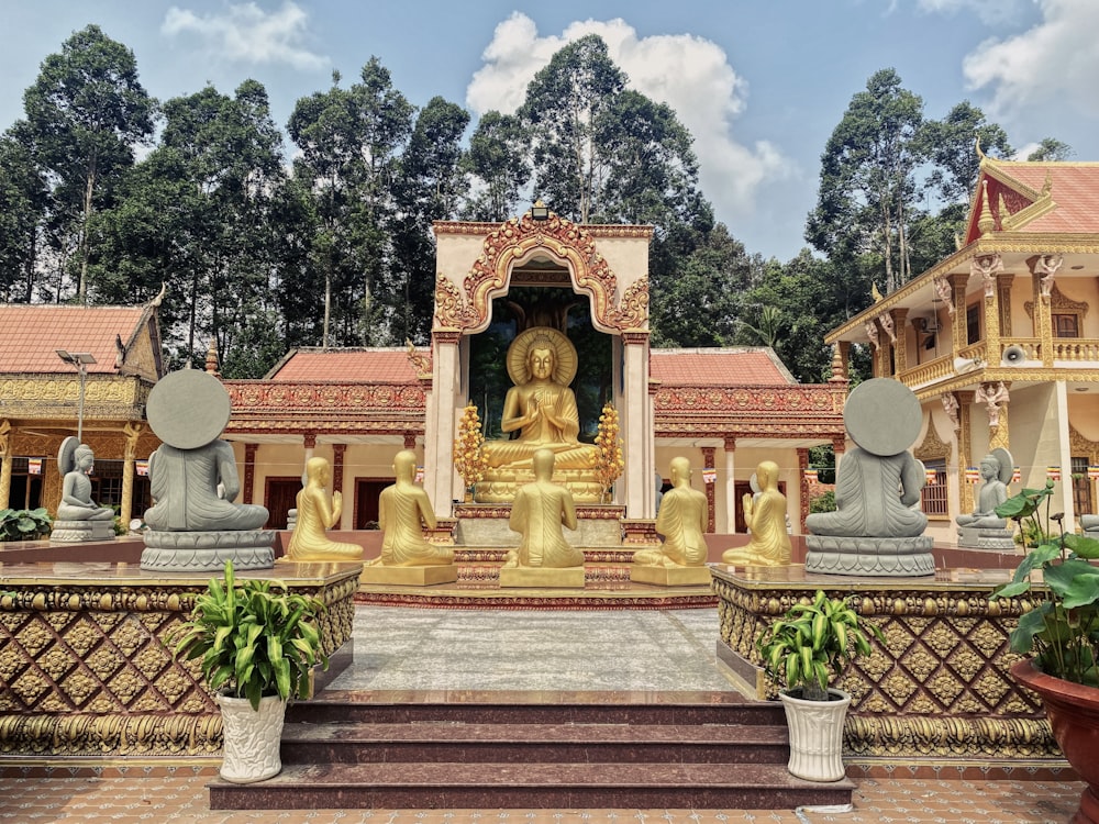 a golden buddha statue sitting in front of a building