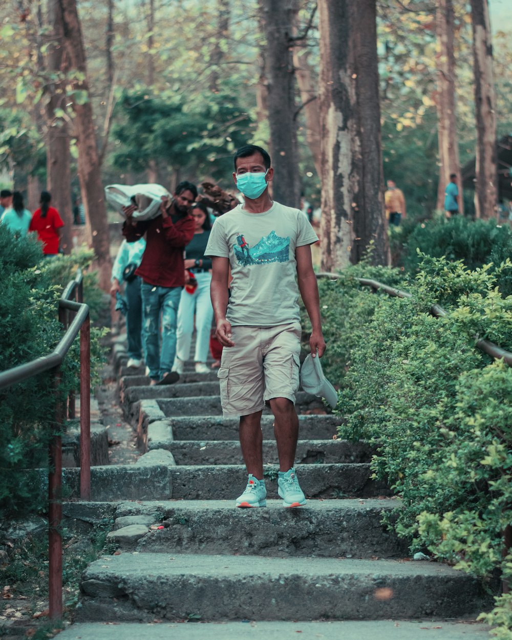 a man wearing a face mask walking down a set of stairs