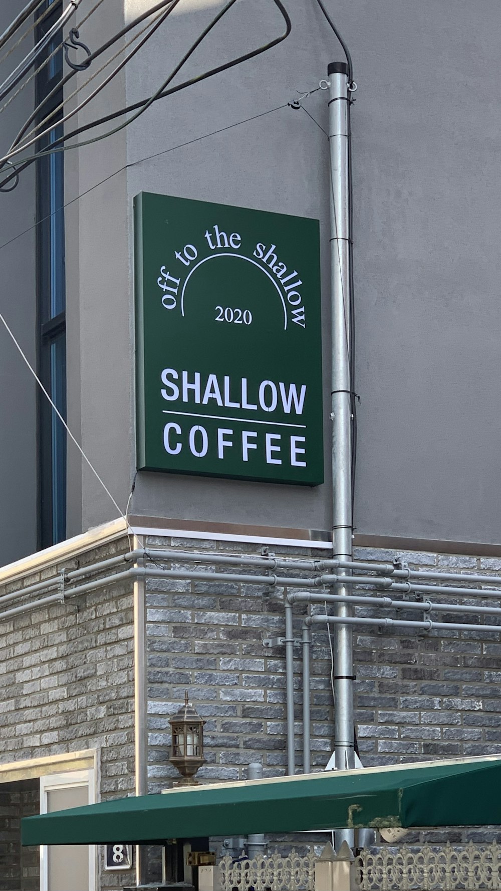 a sign on the side of a building that says shallow coffee
