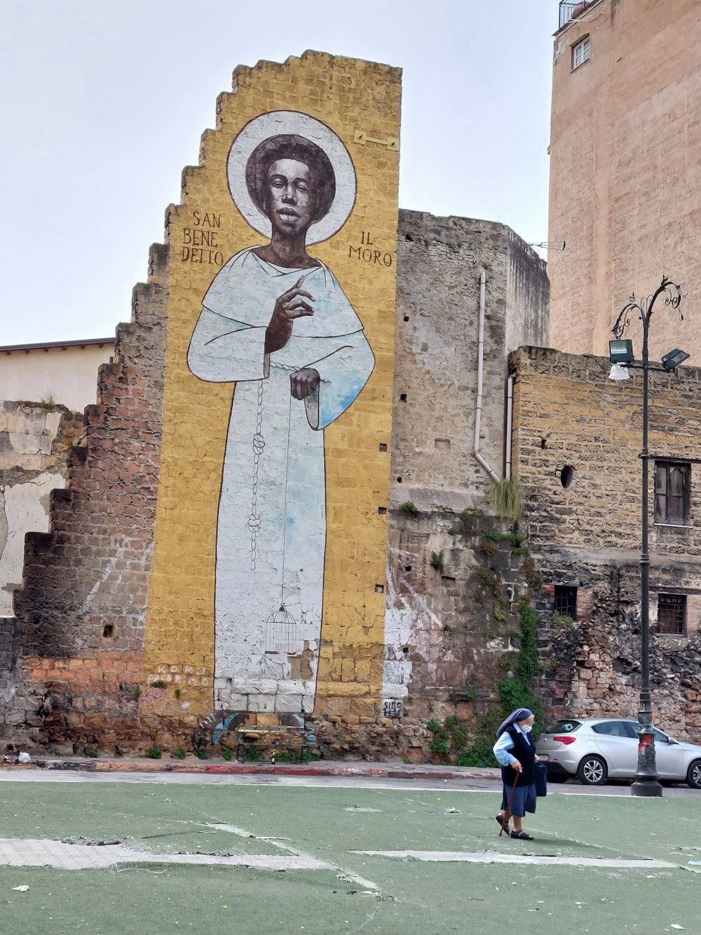 a man standing in front of a large mural of jesus