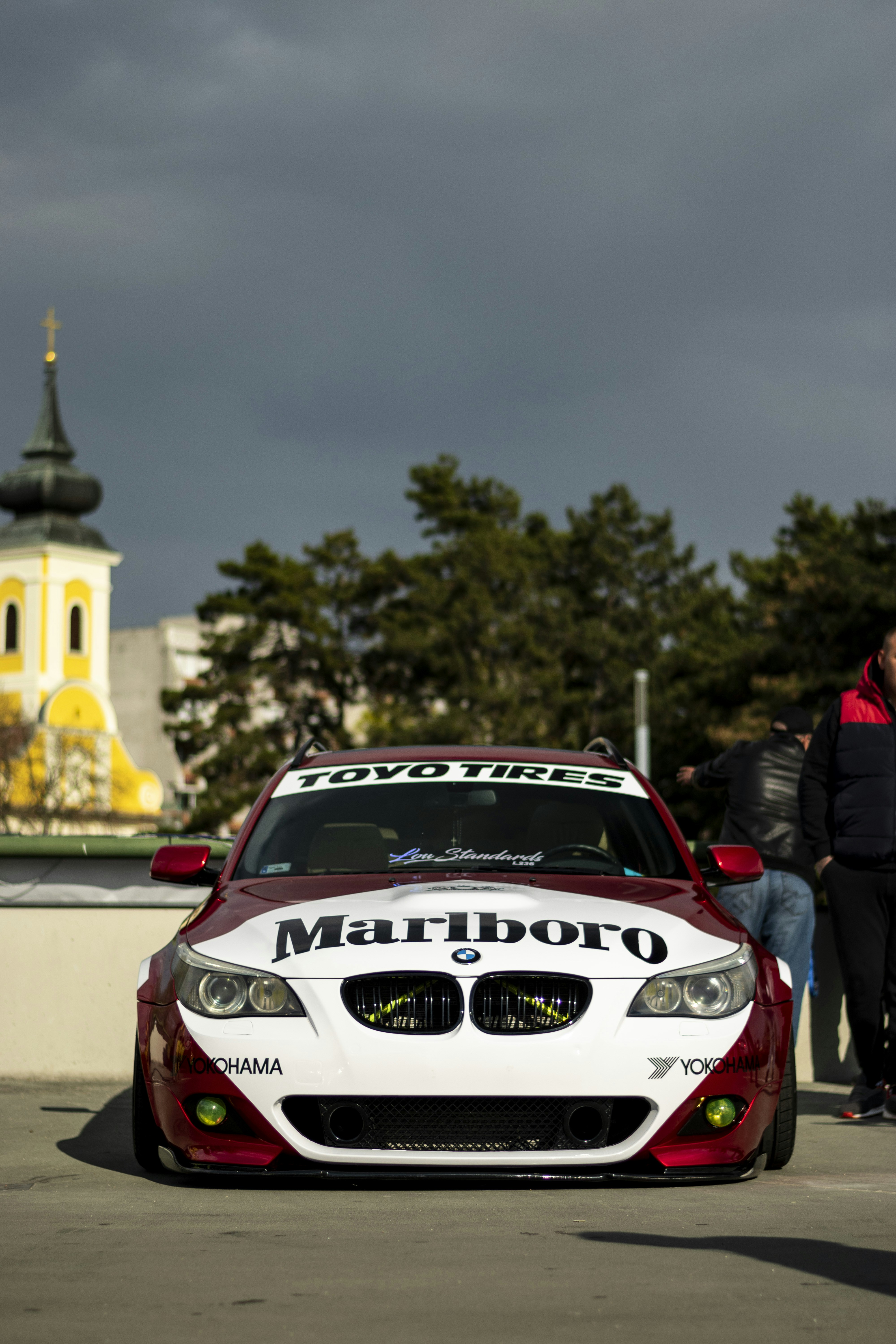 a red and white car parked in front of a building