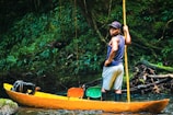 a man standing on a yellow boat in a river