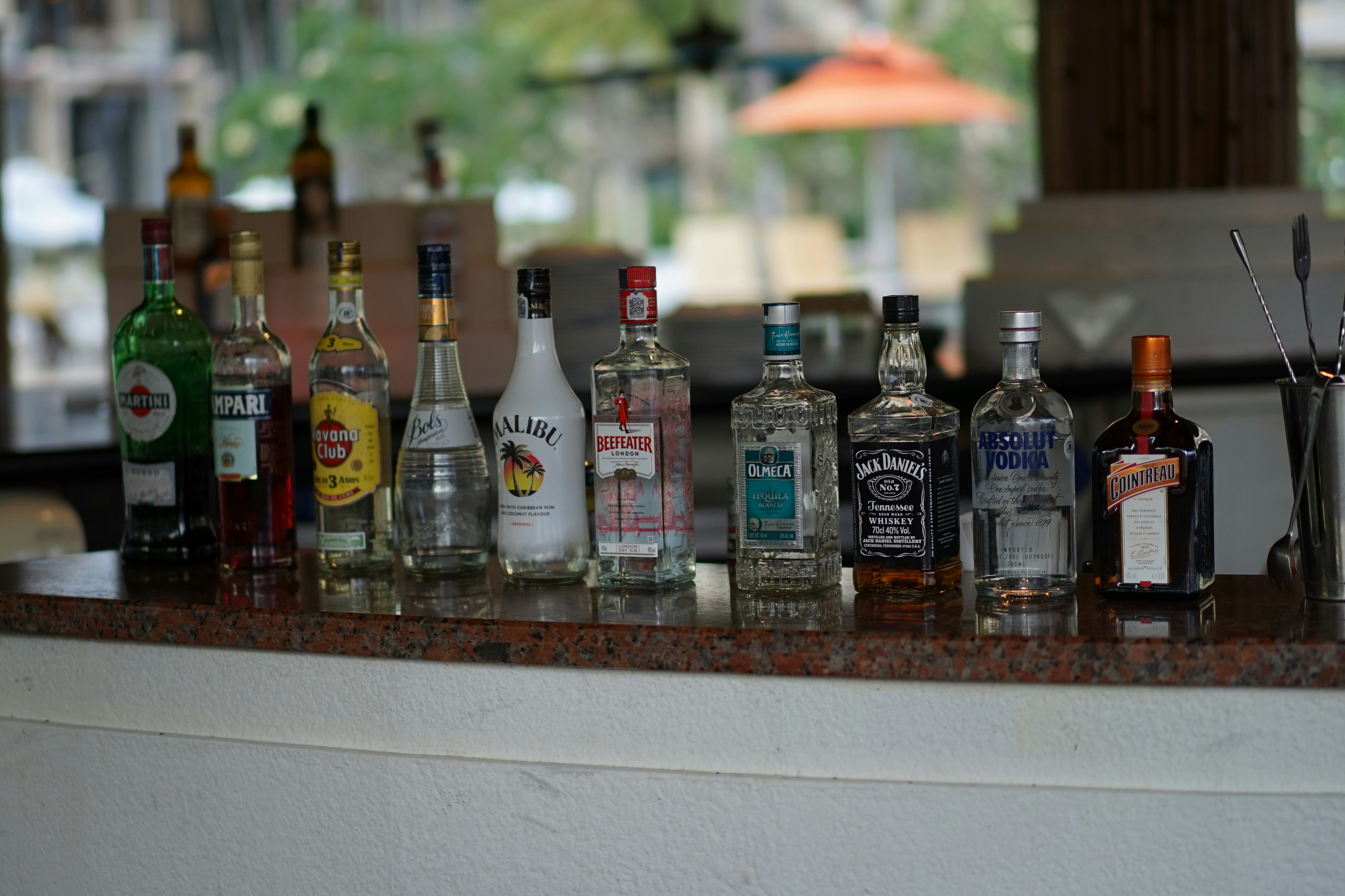 a bunch of liquor bottles lined up on a bar