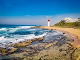 a beach with a light house in the background