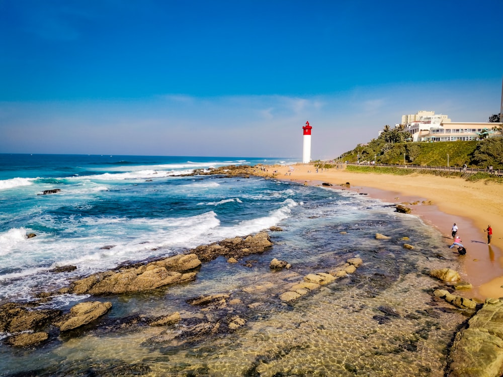 uma praia com um farol no fundo