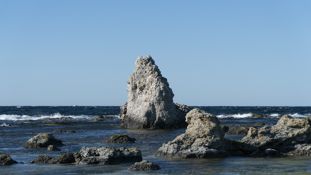a large rock sticking out of the ocean