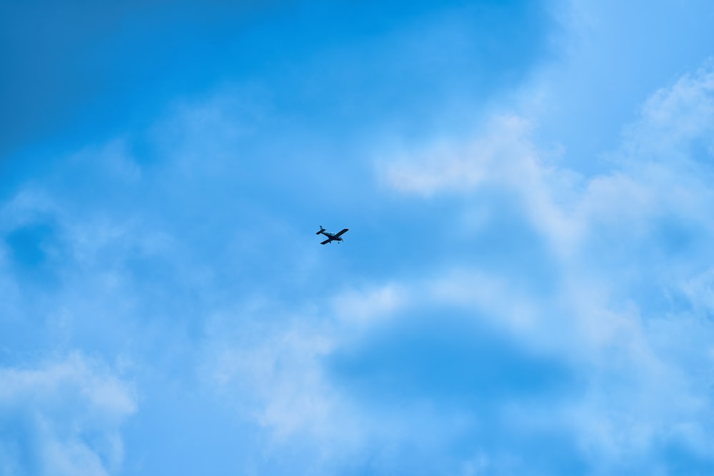 an airplane is flying through the blue sky