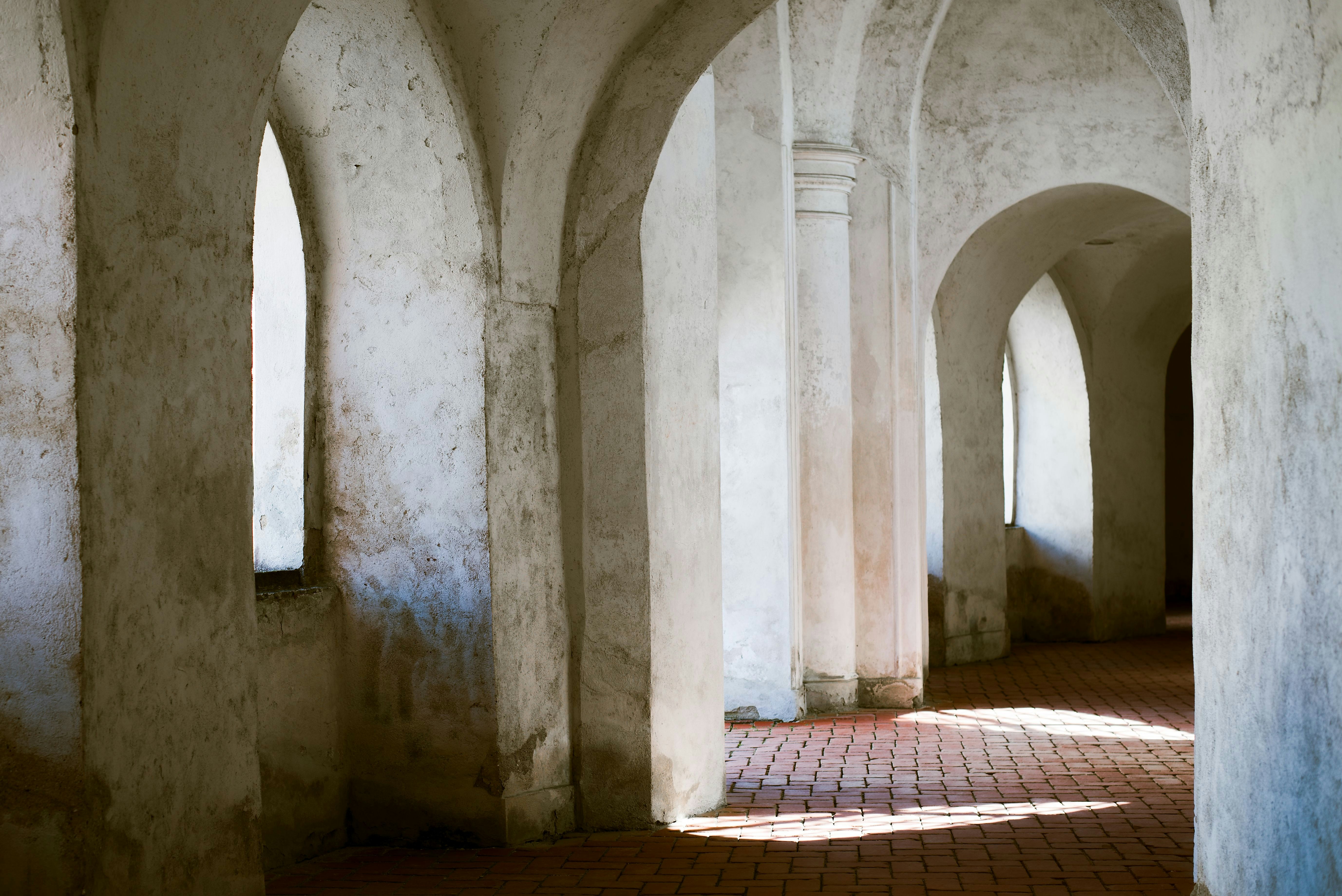 a row of arches in a building with a brick floor