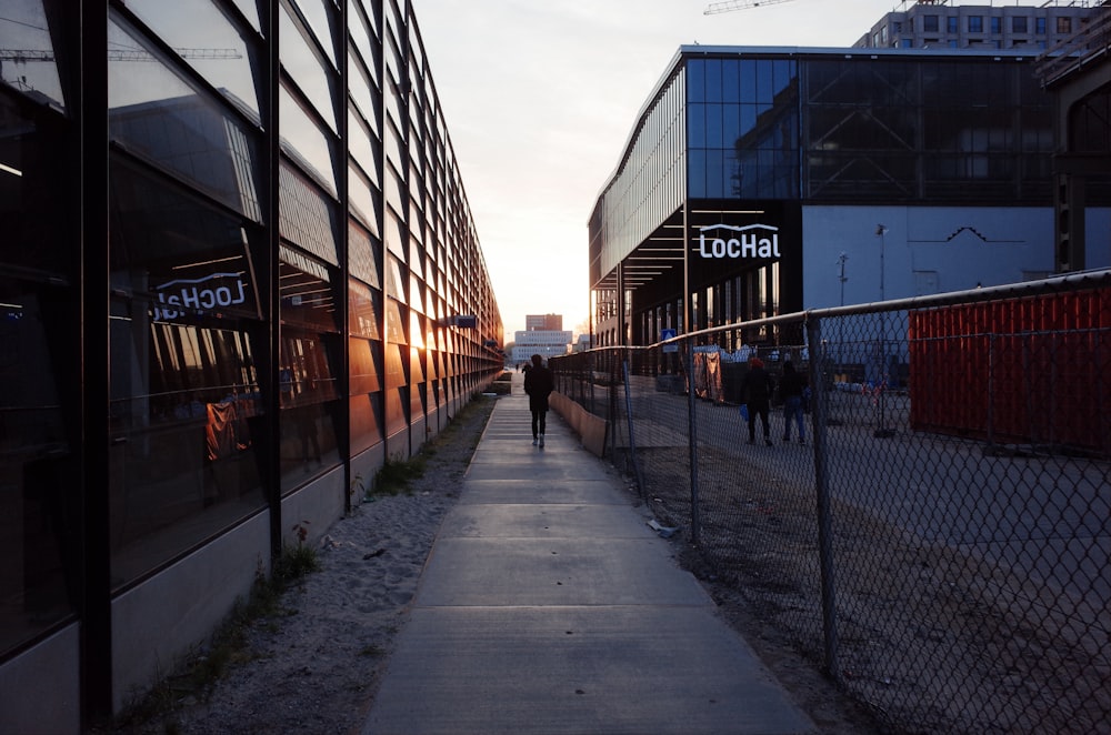 a man walking down a sidewalk next to tall buildings